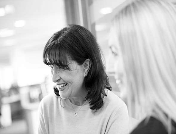 Black and white image of an Elysium Healthcare employees smiling