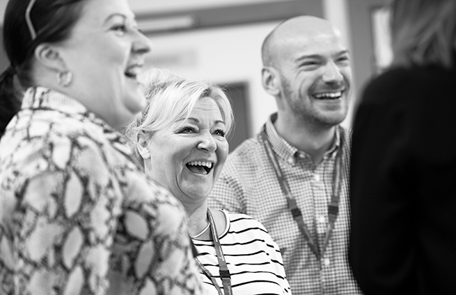 Black and white group shot with Elysium Healthcare employees smiling