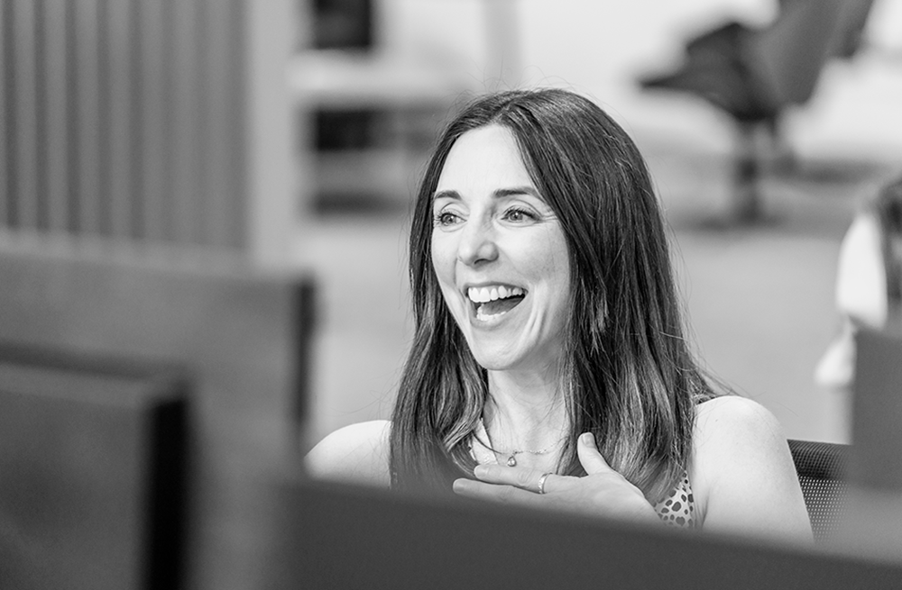 Woman laughing sitting at a desk