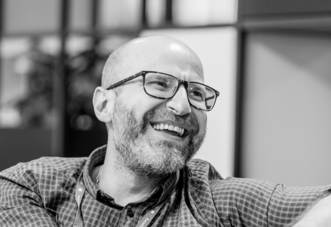 Man who works in healthcare, wearing glasses and is smiling